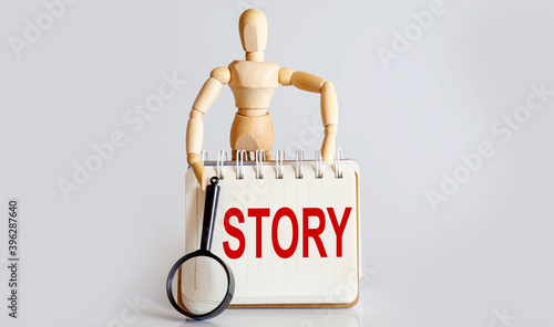 Wallpaper Mural Wooden man shows with a hand to white notepad with text STORY Torontodigital.ca