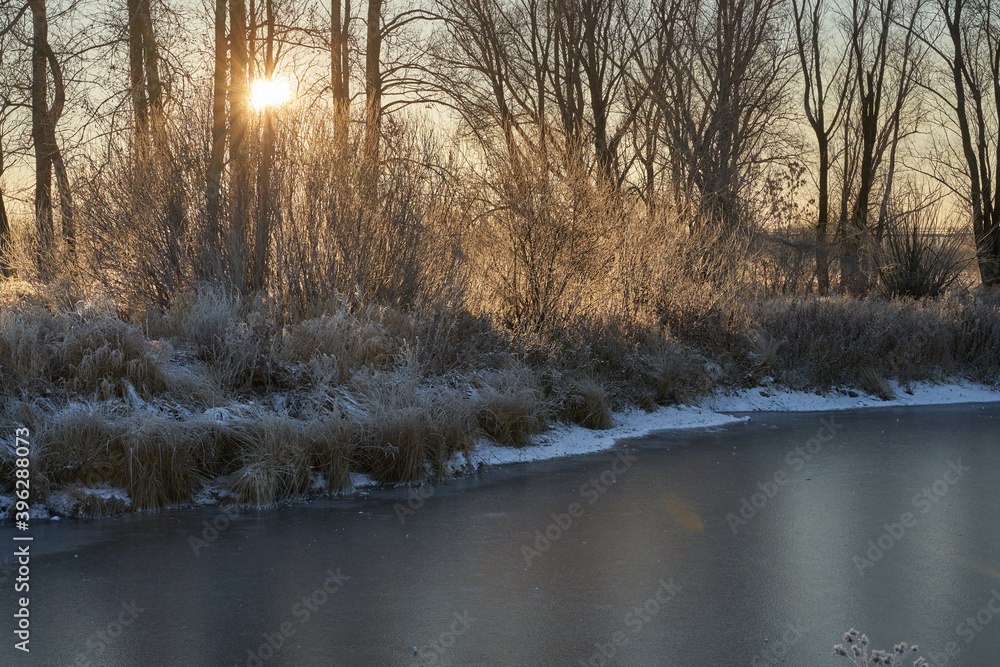 Breath of winter, first ice on the lake, dawn on a frosty morning with frost on the grass, close-up of frost, patterns on the first ice. Breath of winter, first ice on the lake, dawn on a frosty morning with frost on the grass, close-up of frost, patterns on the first ice.