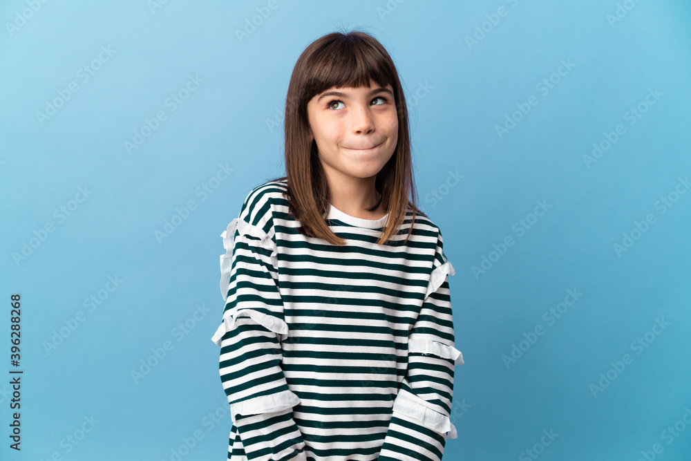 Little girl over isolated background having doubts while looking up Little girl over isolated background having doubts while looking up