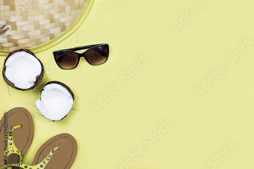 hat, glasses, coconut, sandals lie on a yellow background. Tourism theme