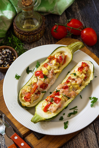 Healthy food. Baked zucchini stuffed with meat and tomatoes on rustic wooden table.