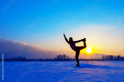 silhouette of a sports girl at sunset in winter © Александр Горшков
