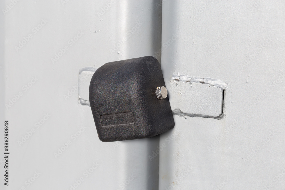 Locked padlock hanging on the closed metal gate outdoors