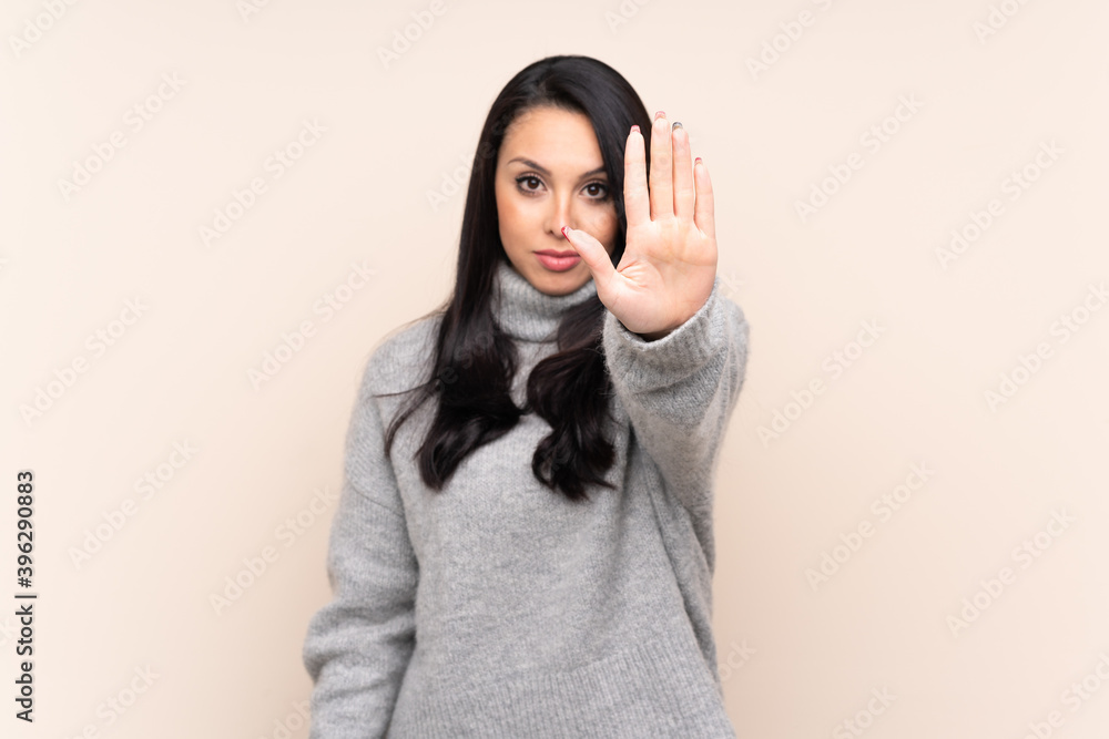 Young Colombian girl over isolated background making stop gesture Young Colombian girl over isolated background making stop gesture