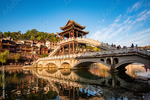 the river, the boat, stone bridge and the old houses at ancient phoenix town in the morning at Hunan, China. 