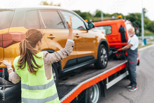 Foto Worried middle age business woman talking with senior man who is working in towing service