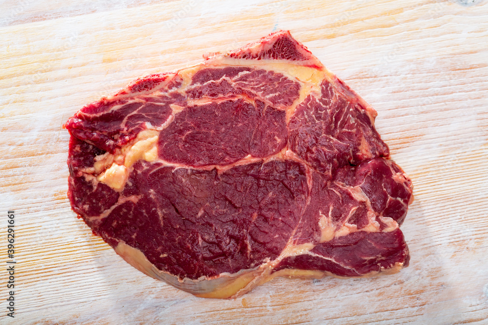 Obraz premium Image of raw cow chop on natural wooden surface, before cooking