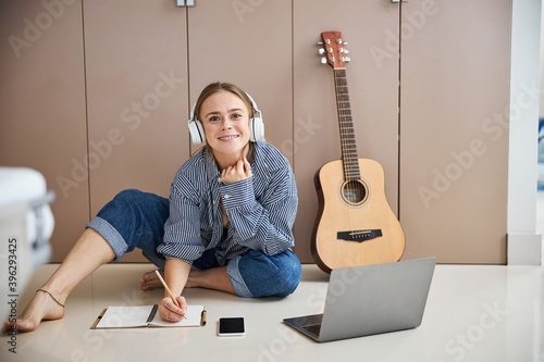 Photography Cheerful female musician writing songs at home