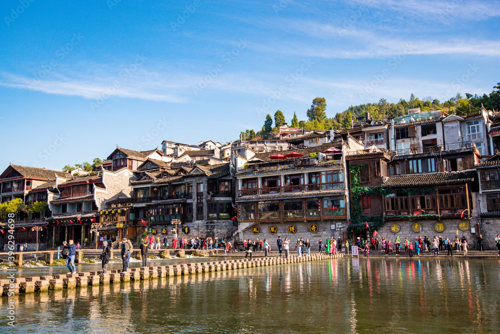 Tourists walking along Phoenix Ancient Town (Fenghuang County). Awesome view of scenic old street. Fenghuang is a popular tourist destination of Asia.