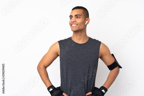 Young African American sport man over isolated white background posing with arms at hip and looking side © luismolinero