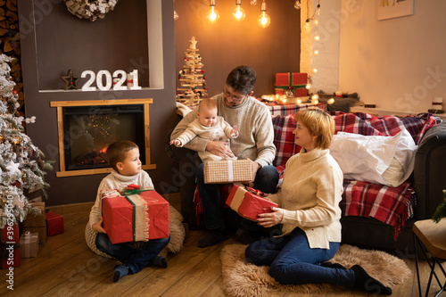 Wallpaper Mural Family Opening Christmas Presents near Christmas tree in modern decorated home, Happy New year 2021 Torontodigital.ca