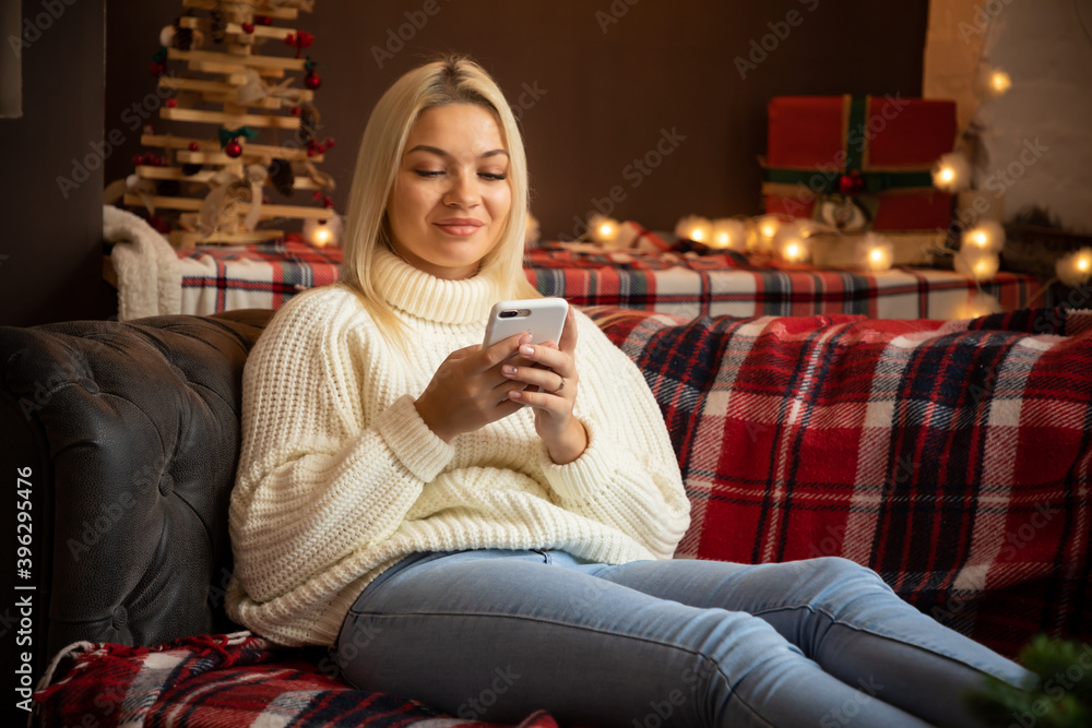 Happy woman at home reading a text message while sitting on sofa in Christmas holiday, Happy New year 2021 Happy woman at home reading a text message while sitting on sofa in Christmas holiday, Happy New year 2021