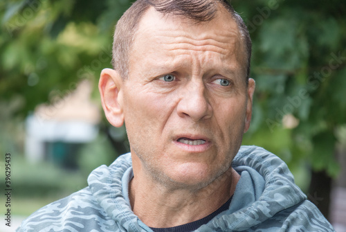 A portrait against the background of nature of a handsome middle-aged man, longingly looking into the distance.