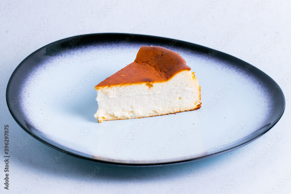 Fototapeta premium San sebastian cake in a ceramic plate isolated on a white background close up.