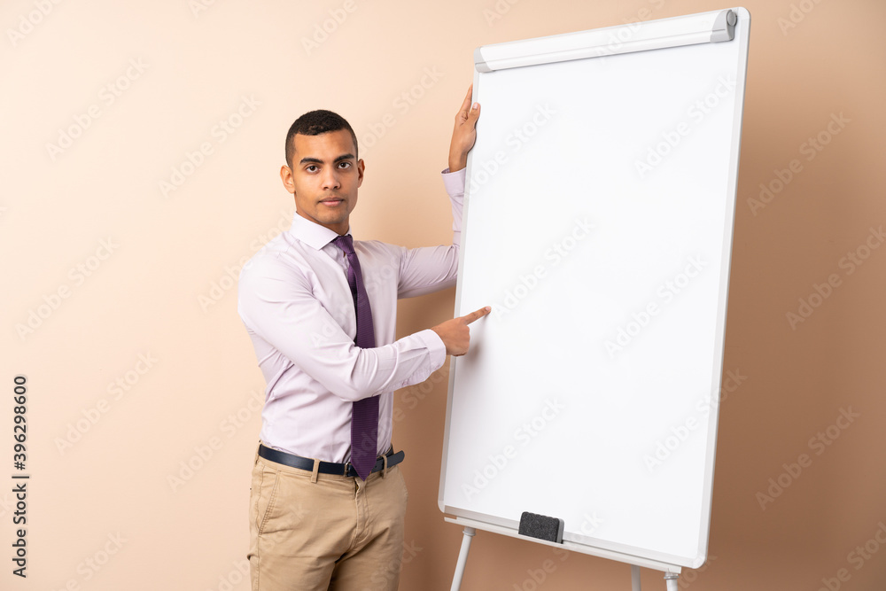 Young business man over isolated background giving a presentation on white board Young business man over isolated background giving a presentation on white board