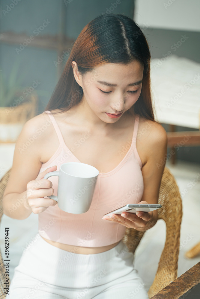 Portrait of beautiful asian woman using smartphone and holding a cup of coffee. Portrait of beautiful asian woman using smartphone and holding a cup of coffee.