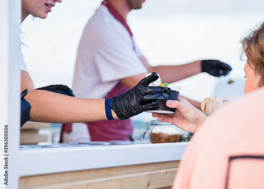 Woman hand taking handmade natural asian stir-fried ice cream at street food festival. Outdoor cooking, gastronomy, takeaway food, and service concept Woman hand taking handmade natural asian stir-fried ice cream at street food festival. Outdoor cooking, gastronomy, takeaway food, and service concept