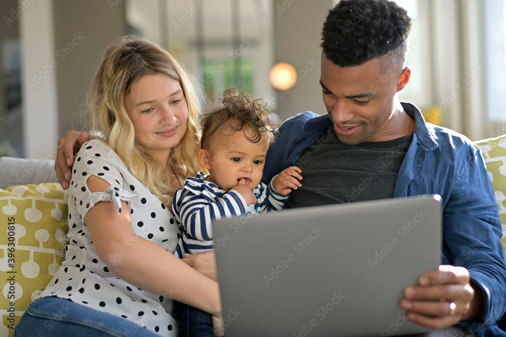 Parents with baby girl using laptop computer at home Parents with baby girl using laptop computer at home