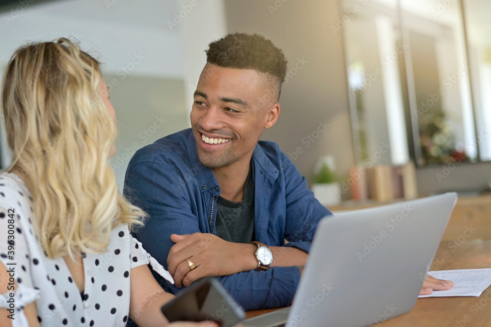 Mixed-raced couple connected on laptop at home Mixed-raced couple connected on laptop at home