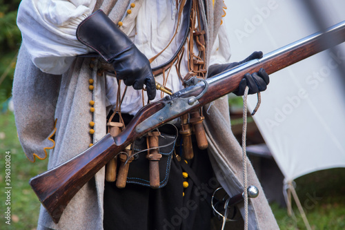 Musketeer preparing to fire muskets at reenactment festival
