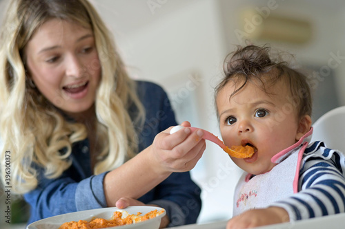 Mom feeding 8-month-old baby girl