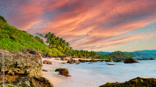 Obraz na płótnie Long exposure. Beautiful and relaxing beach flanked by green palm trees at sunset. Varkala, Kerala, India. w salonie