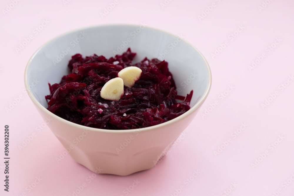 boiled beet with garlic in the bowl on pink background boiled beet with garlic in the bowl on pink background