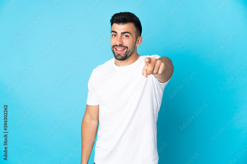 Caucasian man over isolated blue background pointing front with happy expression Caucasian man over isolated blue background pointing front with happy expression