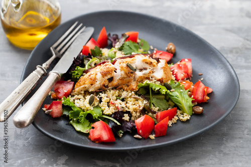 chicken with vegetables and quinoa on dish on ceramic background