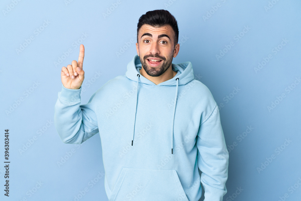 Caucasian man over isolated blue background pointing up a great idea Caucasian man over isolated blue background pointing up a great idea