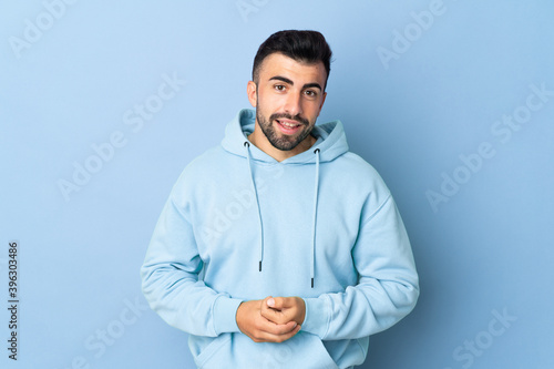 Caucasian man over isolated blue background laughing