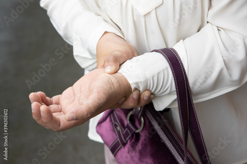 old asian senior woman suffering from trigger finger, cps or carpal tunnel syndrome, gout disease, arthritis inflammation