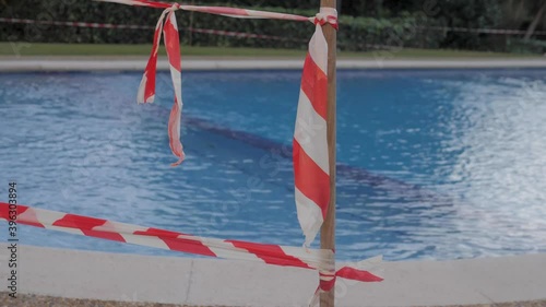 Closed slide in public swimming pool during coronavirus pandemic, caution tape, lockdown public space