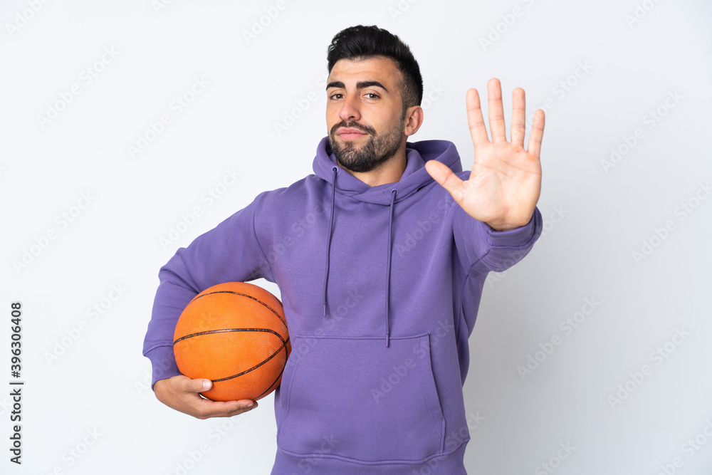 Man playing basketball over isolated white wall counting five with fingers Man playing basketball over isolated white wall counting five with fingers
