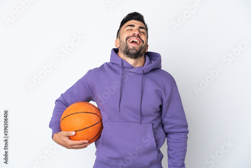 Man playing basketball over isolated white wall laughing