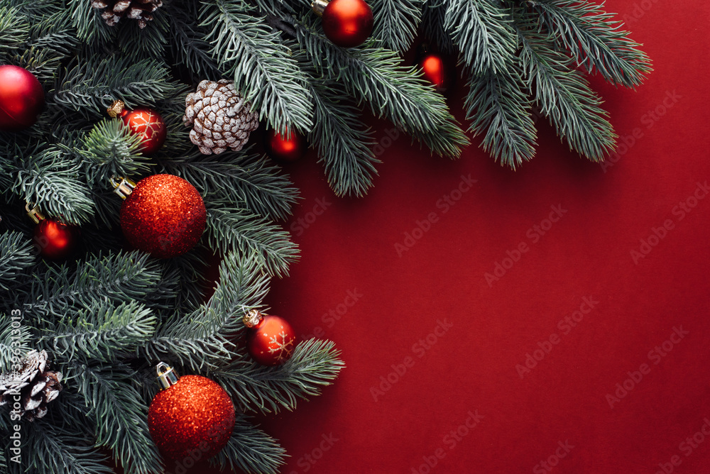 Christmas red decorations, fir tree branches on red background. Flat lay. Nature Christmas concept. Flat lay, top view, copy space