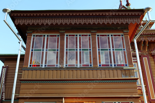 Red ornamental carved windows, frames on vintage wooden house (