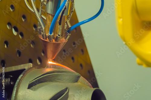 Metalworking, robotic, industrial concept. Direct metal deposition - advanced additive laser melting and powder spray manufacturing technology for repair, rebuild metal workpieces - close up