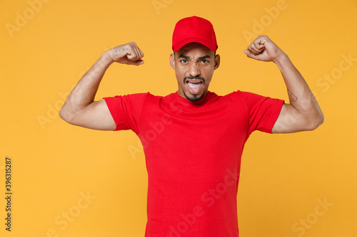 Delivery employee african man in red cap blank print t-shirt uniform workwear work courier service on quarantine covid-19 virus concept isolated on yellow background studio. Tattoo translation life. © ViDi Studio
