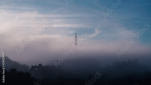Early morning sunrise with thicker fog or mists over a 5G comm tower