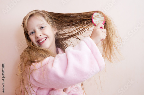 Bild auf Leinwand little girl combs her hair after a shower