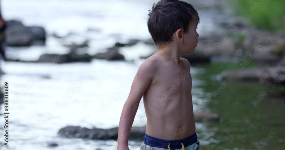 Toddler boy looks around at rivers edge nervously for parents - close up on face Toddler boy looks around at rivers edge nervously for parents - close up on face