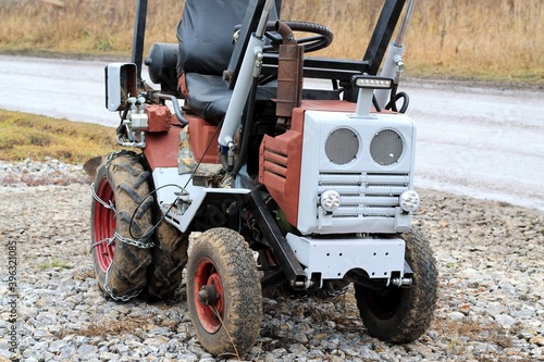 Wallpaper Mural Old mini-tractor of brown color, on the background of a gray road. Torontodigital.ca