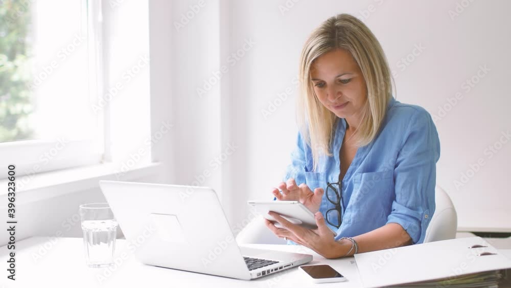 Businesswoman using digital tablet and laptop at home Businesswoman using digital tablet and laptop at home