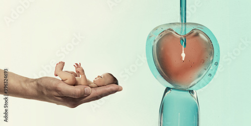 Ovum with needle and sperm for artificial insemination or in vitro fertilization and human baby on palm of hand. Concept of artificial insemination or fertility treatment. photo