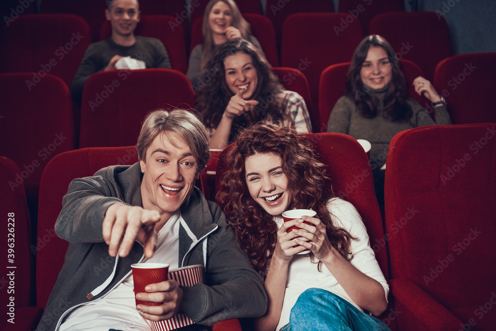 People sit in the cinema and watch a funny comedy.