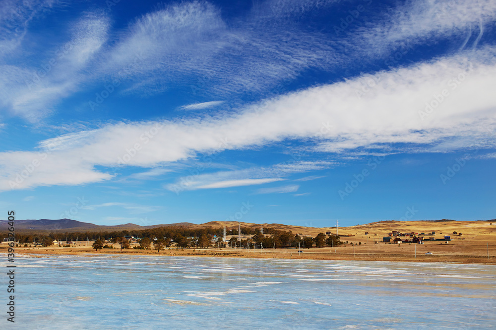 Lake Baikal in winter. Beautiful blue sky with clouds over Olkhon island.