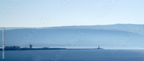 seascape, coast with a lighthouse in a blue haze