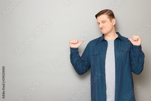 Obraz na plátně Portrait of funny proud man pointing with both thumbs at himself