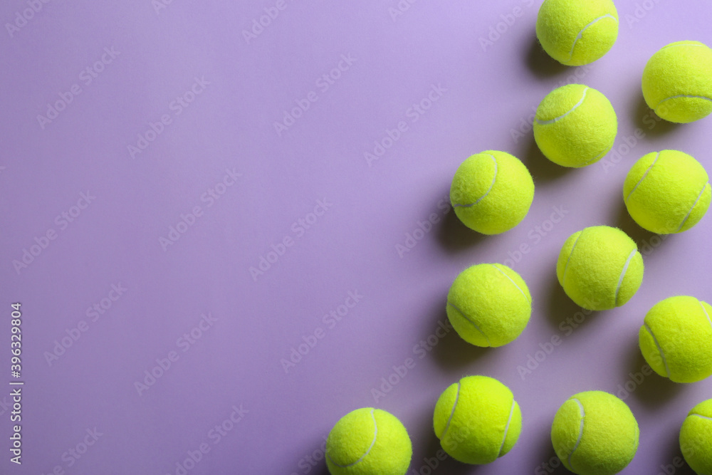 Tennis balls on violet background, flat lay. Space for text